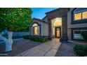 Inviting front exterior boasts stone accents, elegant arched entryway, and manicured greenery leading to the front door at 1532 N Ogden --, Mesa, AZ 85205