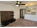 Living room boasts modern ceiling fan, wood accent wall and open kitchen view at 1720 E Thunderbird Rd # 2087, Phoenix, AZ 85022
