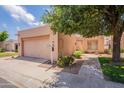 Charming single-story home featuring a two-car garage and a neatly landscaped front yard with mature trees at 17224 N Zuni Trl, Surprise, AZ 85374
