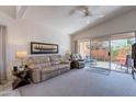 Comfortable living room with plush seating, a ceiling fan, and access to the patio via a sliding glass door at 17224 N Zuni Trl, Surprise, AZ 85374
