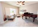 Bright living room featuring tile flooring, a ceiling fan, and plantation shutters at 25935 W Potter Dr, Buckeye, AZ 85396