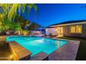 Inviting backyard pool area with lush landscaping, lounge seating, and outdoor dining at 26879 N 100Th Ln, Peoria, AZ 85383