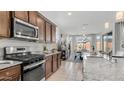 Well-equipped kitchen with granite countertops, stainless steel appliances, and an open view to the dining area at 27636 W Runion Dr, Buckeye, AZ 85396
