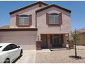 Two-story home with a front-facing two-car garage and rock landscaping at 284 W Settlers Trl, Casa Grande, AZ 85122