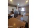 A well-lit kitchen featuring stainless steel appliances, white cabinets, and tile flooring at 284 W Settlers Trl, Casa Grande, AZ 85122