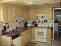 Functional kitchen with wooden cabinets and a standard appliance package at 4107 E Bloomfield Rd, Phoenix, AZ 85032