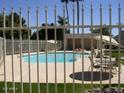Community swimming pool and lounge area behind a secure perimeter fence at 4107 E Bloomfield Rd, Phoenix, AZ 85032