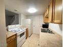 Functional kitchen featuring white appliances, wood cabinets and tile flooring at 4714 E Pueblo Ave, Phoenix, AZ 85040
