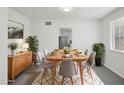 Dining room with a light wood table set for six, complemented by contemporary decor and natural light at 541 W Vernon Ave, Phoenix, AZ 85003