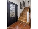 Elegant foyer with tiled floor, wood stairs, decorative door and framed artwork at 55 E Pierson St, Phoenix, AZ 85012