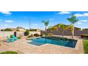 Inviting pool area with a sparkling pool, palm trees, and comfortable seating for relaxation at 6602 S Constellation Way, Gilbert, AZ 85298