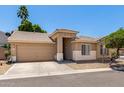 Inviting home with a well-manicured front yard, complemented by a tan exterior and a convenient two-car garage at 6631 E Rhodes St, Mesa, AZ 85215