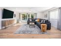Bright living room with a gray sectional sofa, wood accents, and sliding glass doors at 6831 E Presidio Rd, Scottsdale, AZ 85254
