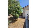 Landscaped front yard with mature trees and shrubs leading to the front door and a view of the garage at 7251 E Grouse Ct, San Tan Valley, AZ 85143