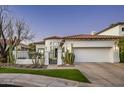 Elegant home featuring a red tile roof, gated courtyard, three car garage, and desert landscaping at 7614 E Cactus Wren Rd, Scottsdale, AZ 85250