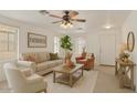 Inviting living room with neutral tones, ceiling fan, and cozy furnishings at 8924 E Portobello Ave, Mesa, AZ 85212