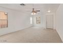 Spacious living room with neutral walls and carpet, featuring a front door and ample natural light at 8924 E Portobello Ave, Mesa, AZ 85212