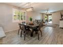 This dining area features wood flooring, designer light fixture, and is open to a living area and patio at 9834 E Thatcher Ave, Mesa, AZ 85212