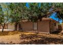 Charming brick home with mature trees, providing shade and enhancing the property's appeal and character at 1170 E Carmen St, Tempe, AZ 85283