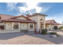 View of the house featuring stone landscaping, arched windows, and a red tiled roof at 12899 W Pasadena Ave, Litchfield Park, AZ 85340