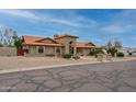 Charming single-story home featuring a red tile roof, arched windows, and low-maintenance desert landscaping at 12899 W Pasadena Ave, Litchfield Park, AZ 85340