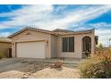 Charming tan single-story home with desert landscaping, two-car garage and arched front entry at 15134 N 138Th Ln, Surprise, AZ 85379