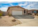 Single-story home with desert landscaping, attached two car garage, and covered arched entry at 15134 N 138Th Ln, Surprise, AZ 85379