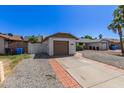 This home features a single-car garage with driveway and low maintenance rock landscaping at 1633 E Beverly Ln, Phoenix, AZ 85022