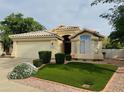 Charming single story home featuring a well-maintained lawn, desert landscaping, and a two car garage at 16646 N 35Th Way, Phoenix, AZ 85032