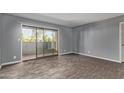 Neutral living room with sliding glass doors, wood-look floors, and baseboards at 1730 W Emelita Ave # 2027, Mesa, AZ 85202
