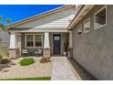 Charming front porch features decorative stone accents, a cozy seating area, and well-maintained landscaping at 17362 W Wildwood St, Surprise, AZ 85388