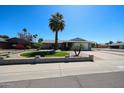 Attractive home with vibrant lawn, mature palm trees, and a well-maintained brick-lined driveway at 17415 N 57Th Ave, Glendale, AZ 85308