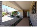 Inviting covered porch with a charming front garden and decorative accents leading to the front door at 17415 N 57Th Ave, Glendale, AZ 85308