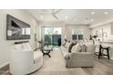 Cozy living room with a gray sofa, white armchair, and sliding glass doors to the backyard at 1829 N 43Rd Ter, Phoenix, AZ 85008