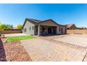 Expansive backyard featuring a covered patio, desert landscaping, and a brick-paved entertaining area at 18508 W Galveston St, Goodyear, AZ 85338