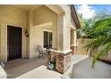 Welcoming covered porch with stone accents, seating area, security door and lush greenery at 20140 N 269Th Dr, Buckeye, AZ 85396