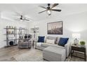 Cozy living room featuring neutral tones, comfortable seating, ceiling fans, and stylish decor at 2236 E Rawhide St, Gilbert, AZ 85296