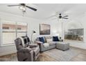 Inviting living room with large windows, comfortable seating, a ceiling fan, and a relaxed ambiance at 2236 E Rawhide St, Gilbert, AZ 85296