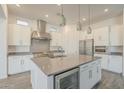 Modern kitchen with white cabinetry, stainless steel appliances, a center island, and pendant lighting at 28917 N 66Th Ave, Phoenix, AZ 85083