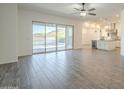 Bright living room featuring wood-look tile floors, sliding glass doors, and views of the backyard pool at 28917 N 66Th Ave, Phoenix, AZ 85083