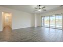 Spacious living room with wood-look tile flooring and sliding glass doors leading to the backyard pool area at 28917 N 66Th Ave, Phoenix, AZ 85083