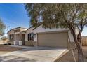 Single-story home featuring a two-car garage, desert landscaping, and a concrete driveway at 30003 W Rockmount Ave, Buckeye, AZ 85396
