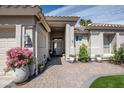 Inviting front entrance with beautiful landscaping, a brick walkway, and a secure gate at 3070 N 148Th Dr, Goodyear, AZ 85395