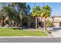 Exterior view of a single Gathering home, featuring a green lawn, palm trees, and a stone facade at 3522 E Cherokee St, Phoenix, AZ 85044