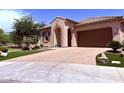 Attractive single-story home showcasing desert landscaping, an arched entryway, a paved driveway, and an attached garage at 3780 E Rakestraw Ln, Gilbert, AZ 85298