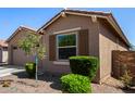 Attractive home exterior showcasing a manicured yard, desert landscaping, and inviting window shutters at 44837 W Horse Mesa Rd, Maricopa, AZ 85139