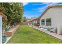 Green backyard featuring a patio, lush landscaping, and a charming outdoor seating area for relaxing and entertaining at 616 E Sheffield Ave, Gilbert, AZ 85296