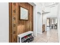 Hallway with a built-in shoe rack and charming wooden accent wall at 6422 W Range Mule Dr, Phoenix, AZ 85083