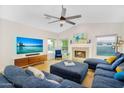Cozy living room with a fireplace, large TV, blue sectional, and ceiling fan at 824 W Mesquite St, Gilbert, AZ 85233