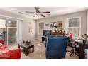 Cozy living room with carpet floors, a ceiling fan, and a sliding glass door at 8244 W Albeniz Pl, Phoenix, AZ 85043